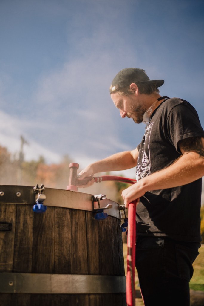 brewer Jeremy Inzer at work at the farmhouse brewery, hosing out a vessel