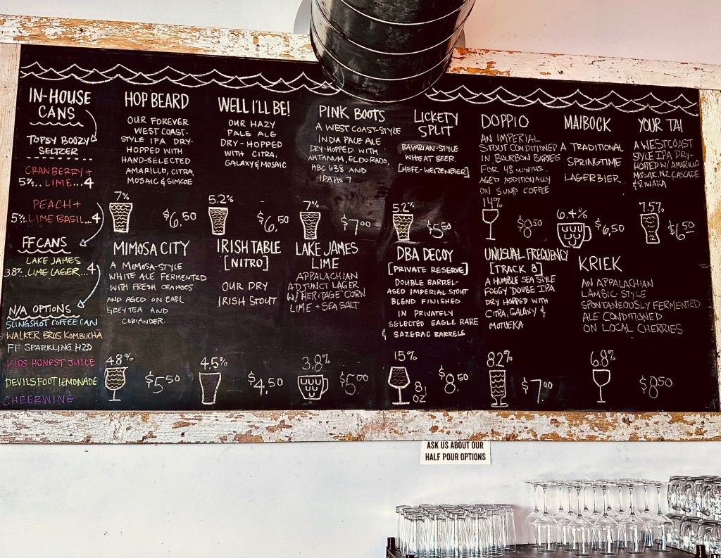Fonta Flora farmhouse brewery's beer taplist on a blackboard, April 2024, with IPAs, DBA Decoy stout, Appalachian Kriek, a lime lager with heritage corn, and some less unusual beers